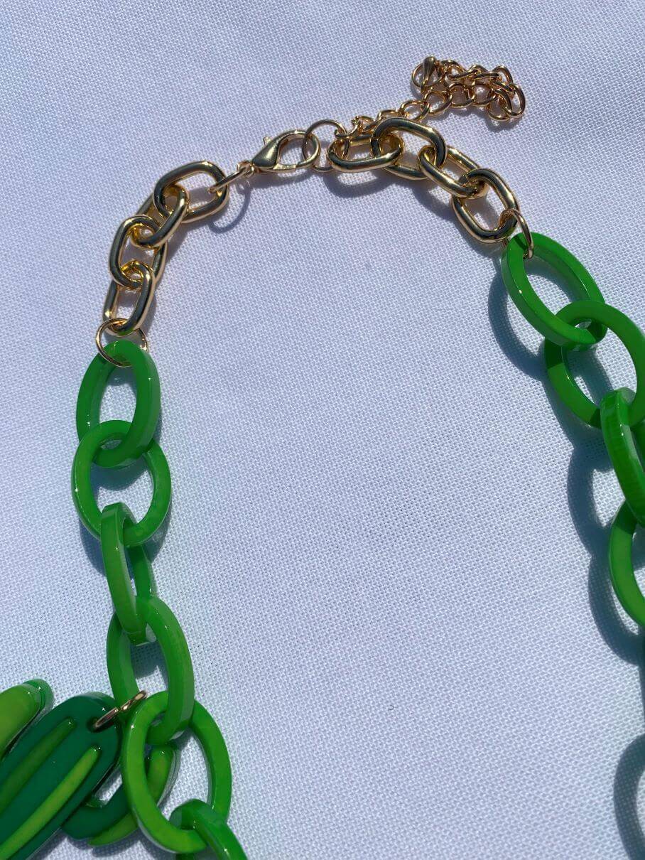 Grüne Plastikkette mit sommerlichen Anhängern