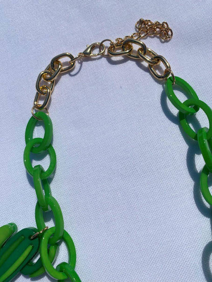 Grüne Plastikkette mit sommerlichen Anhängern